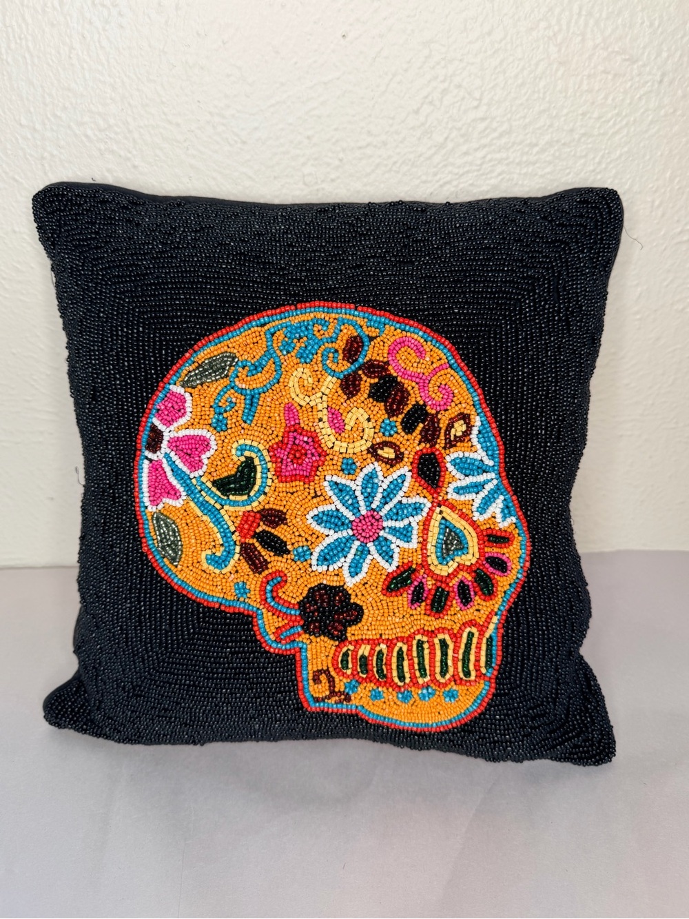 Black beaded 14ā pillow with skull motif
